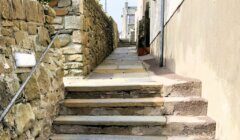 A stone stairway leading up to a stone wall.