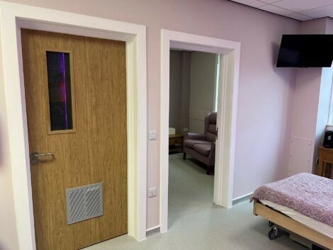 A hospital room with a bed and a television.