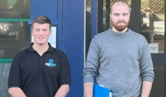 Two men standing in front of a building.