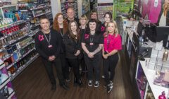 A group of people standing in front of a store.