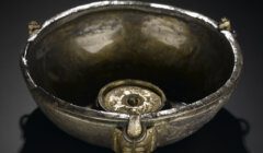 A gold bowl on a black surface.