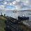 A boat is docked on a rocky shore.