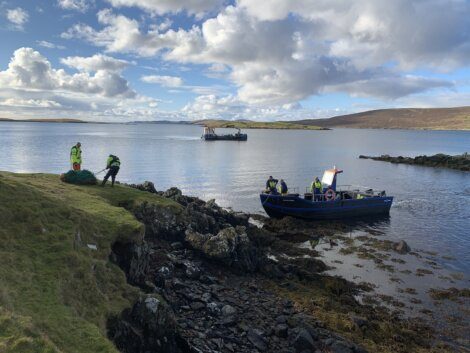 A boat is docked on a rocky shore.