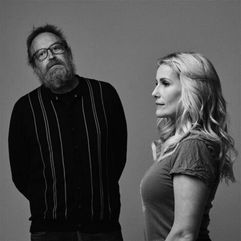 A man and woman standing next to each other in a black and white photo.