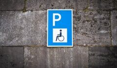 A blue and white sign with a wheelchair on it.