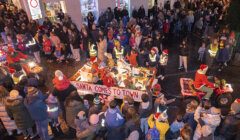 A crowd of people watching a santa claus parade.