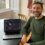 A man sitting at a table with a laptop in front of him.