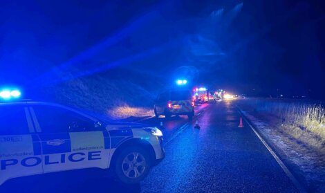 A police car and police cars on a road at night.