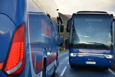 A blue bus on a road.