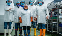 A group of people standing in a factory.