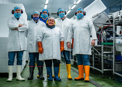 A group of people standing in a factory.