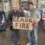 A man holding a sign that says case fire in front of a building.