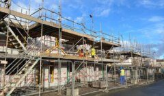 A construction site with scaffolding and a blue sky.