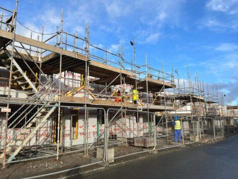 A construction site with scaffolding and a blue sky.