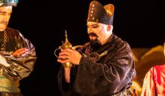 Three men dressed in asian costumes standing next to each other.