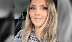 A woman in a leopard print shirt is sitting in a car.