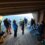 A group of people standing on a deck overlooking the ocean.