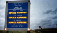 A sign on the side of the road that reads inter island service suspended.