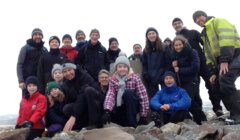 A group of people posing for a photo on a mountain.