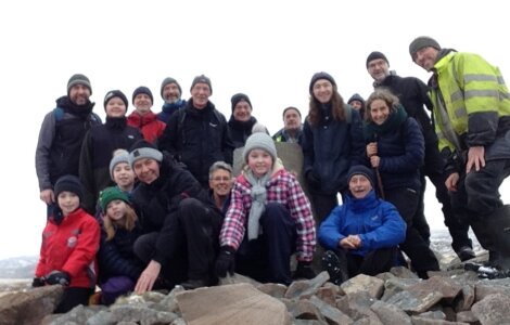 A group of people posing for a photo on a mountain.