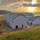 A white building sits on top of a hill overlooking the ocean.