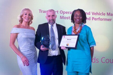 Three people are posing for a picture with an award.