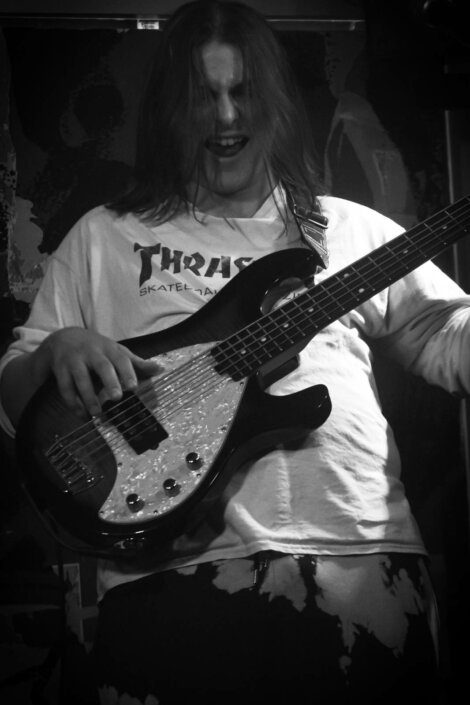 A black and white photo of a man playing a bass.