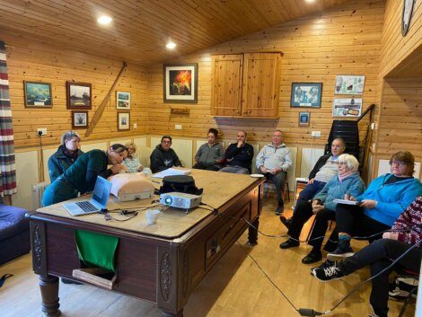 A group of people sitting around a table in a cabin.