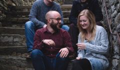 Four people sitting on steps in an alleyway.