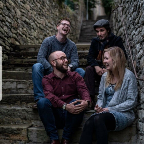 A group of people sitting on steps in an alleyway.