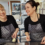 Two women smiling while preparing food in a kitchen.