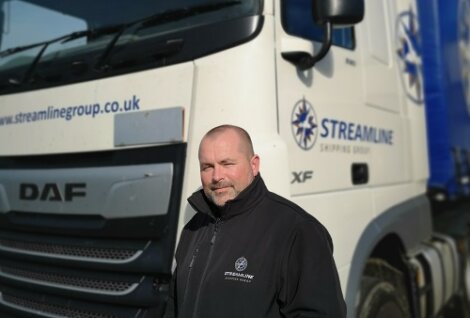 A man standing in front of a truck.