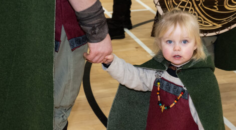 A little girl wearing a cloak.