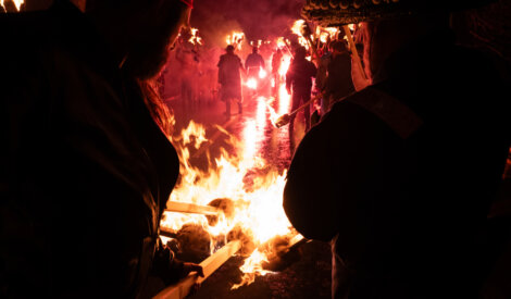 A group of people standing around a fire.