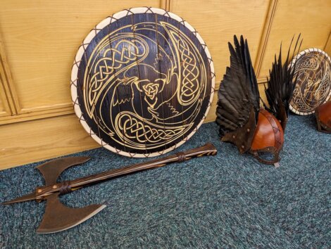 Viking helmets and shields on the floor.