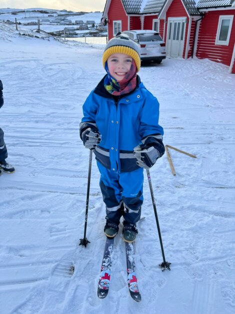 Two children standing on skis in the snow.