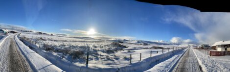 A panoramic view of a snow covered road.