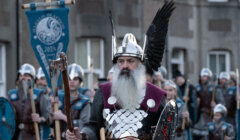 A man in a viking costume is walking down the street.