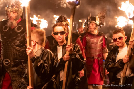 A group of people with torches walking down a street.