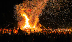 A crowd of people watching a fire.