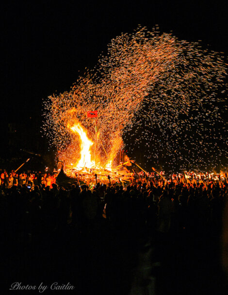 A crowd of people watching a fire.