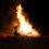 A large group of people watching a bonfire.