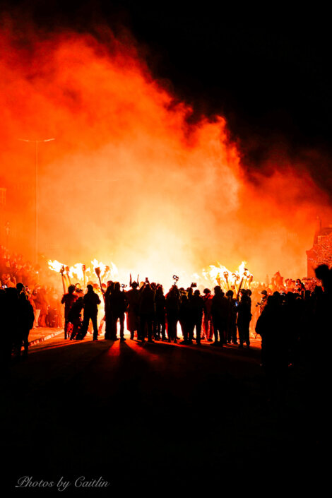 A group of people standing in front of a fire.