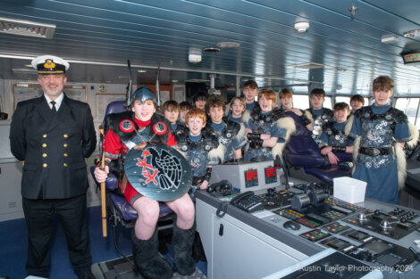 A group of people posing for a picture on a ship.