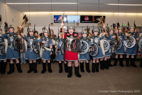 A group of vikings holding shields in an airport.