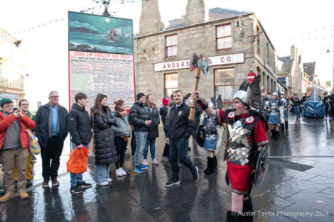 A group of people standing on a wet street.