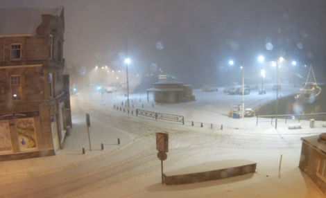 A street covered in snow at night.