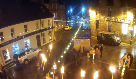 A group of people holding torches in a street.