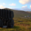 A black sculpture in the middle of a grassy field.