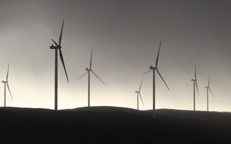 A group of wind turbines on a hill.